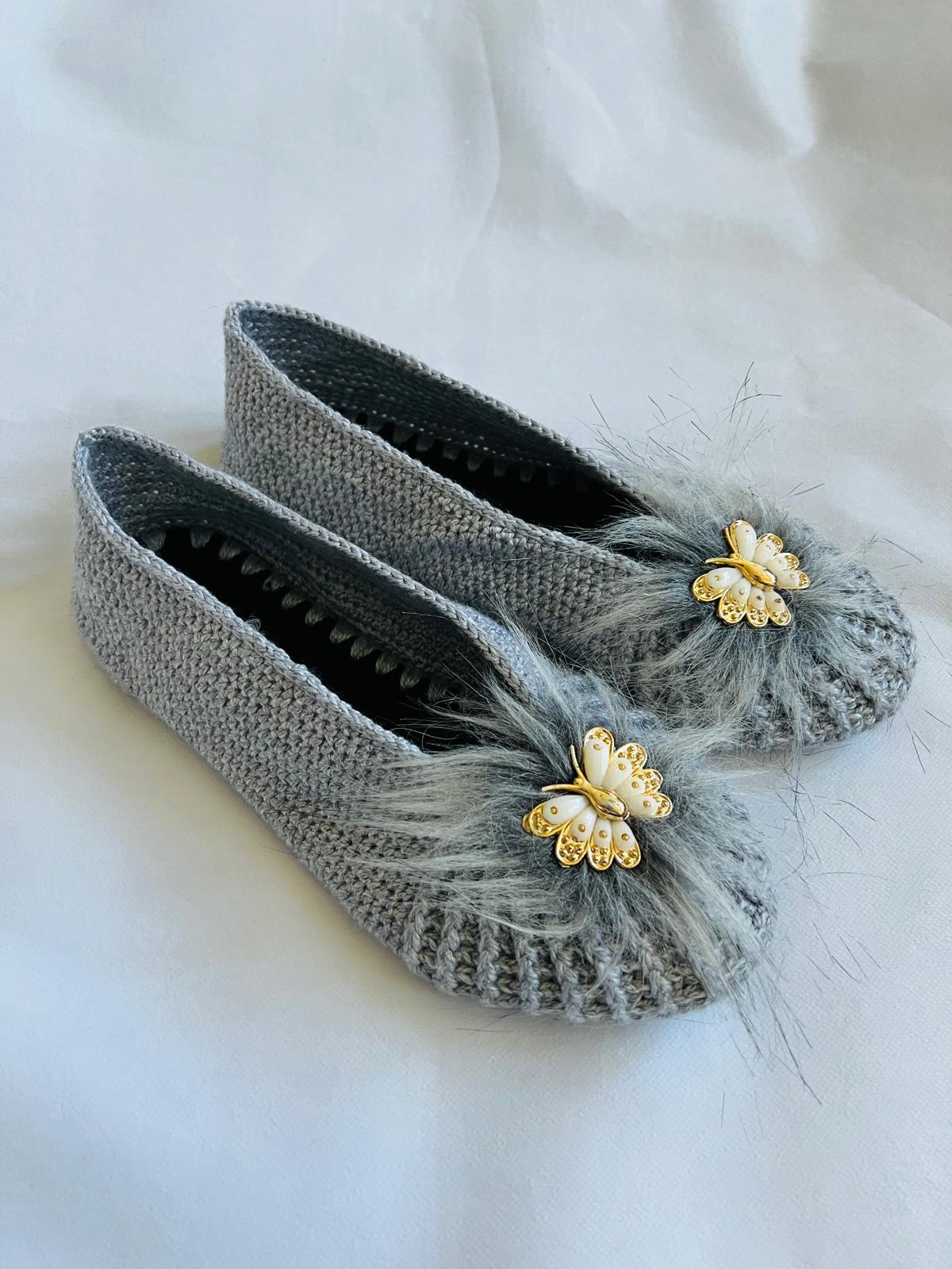 Grey hand-knit ballet slippers with fluffy faux-fur pom and gold butterfly brooch