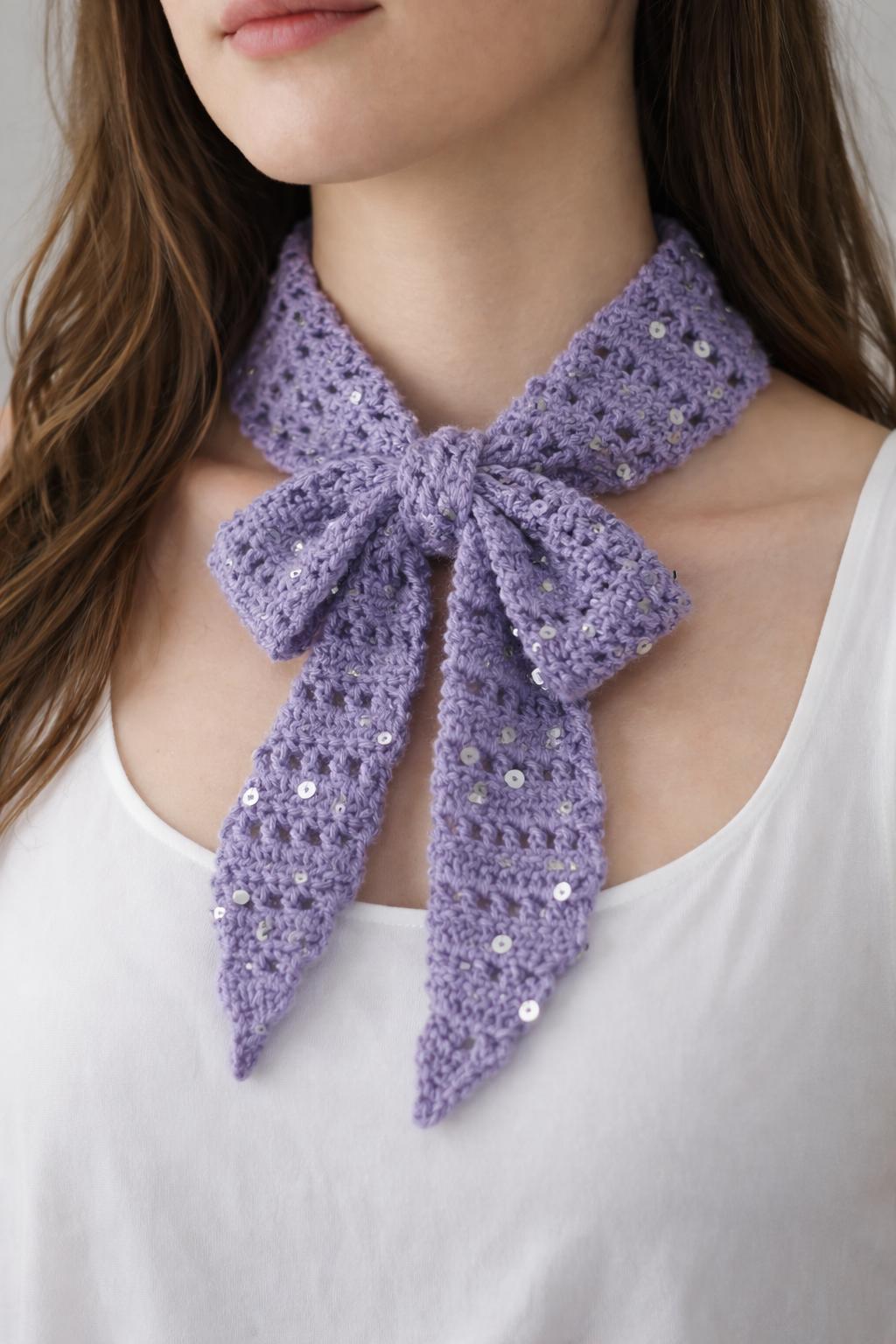 Lavender crochet bow neck scarf with subtle sequins tied around the neck