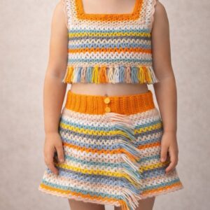 Front view of child wearing matching crochet crop top and skirt set with fringe